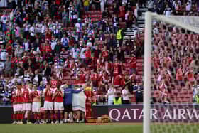 The Denmark players form a shield around their stricken team-mate Christian Eriksen as he receives treatment from medics.