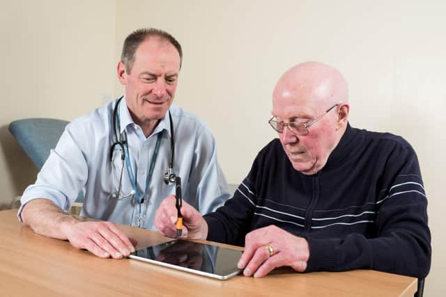 Prof Richard Walker, clinical lead adviser to Edinburgh-based Manus Neurodynamica, pictured with a patient, prior to Covid measures.