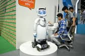 A visitor checks his vitals next to an AI-enabled medical robot at a Bangkok trade show (Picture: Manan Vatsyayana / AFP/ Getty)