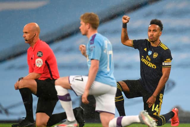 Arsenal striker Pierre-Emerick Aubameyang takes a knee alongside Manchester City midfielder Kevin De Bruyne and Referee Anthony Taylor ahead of Wednesday's Premier League match.