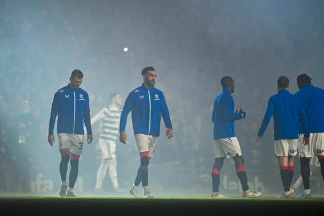 The Rangers players enter the pitch at a raucous Celtic Park,