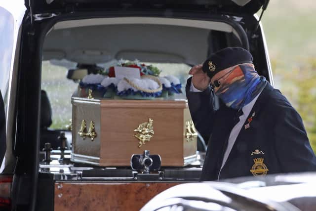 A retired submariner tips his hat as he passes the coffin at Stirling Crematorium, during the funeral of cyclist Anthony Parsons, whose body was found three years after he vanished (picture credit: Andrew Milligan/PA Wire).