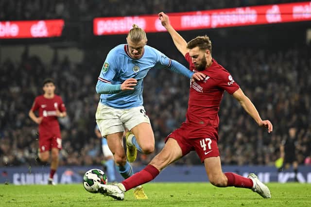 Liverpool's Nat Phillips, pictured tackling Manchester City's Erling Haaland during a League Cup clash last season, has joined Celtic on loan. (Photo by OLI SCARFF/AFP via Getty Images)