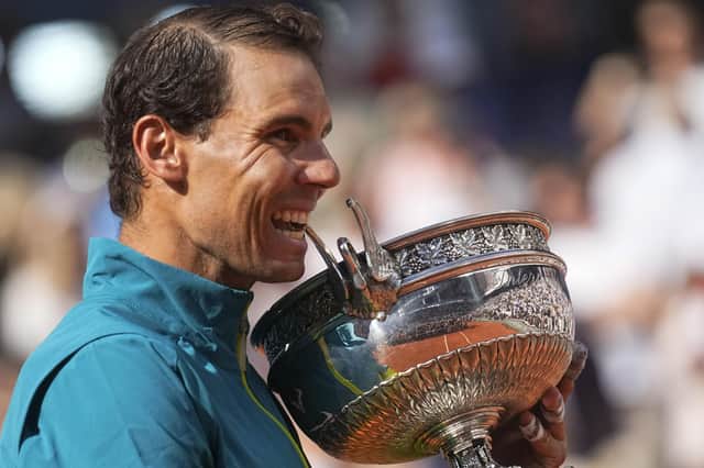 Spain's Rafael Nadal bites the trophy after winning the French Open against Norway's Casper Ruud in three sets, 6-3, 6-3, 6-0.