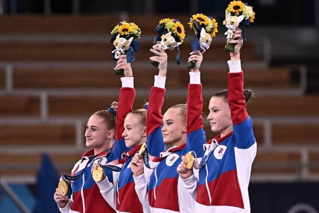 Russian athletes, competing as the neutral Russian Olympic Committee, celebrate winning the gold medal during the podium ceremony of the artistic gymnastics women's team final during the Tokyo 2020 Olympic Games.
