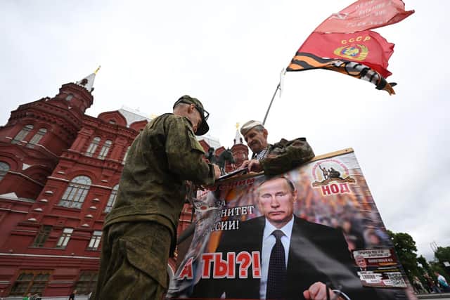 Activists hold a portrait of Russian president Vladimir Putin near Red Square in Moscow. Picture: Natalia Kolesnikova/AFP via Getty Images