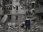 A woman stands among debris of the destroyed house after recent Russian air strike in Chasiv Yar, Ukraine, Sunday, Nov. 27, 2022. Russia unleashed a massive missile barrage on cities across Ukraine early on Thursday, targeting energy infrastructure facilities, Ukrainian officials and media said.