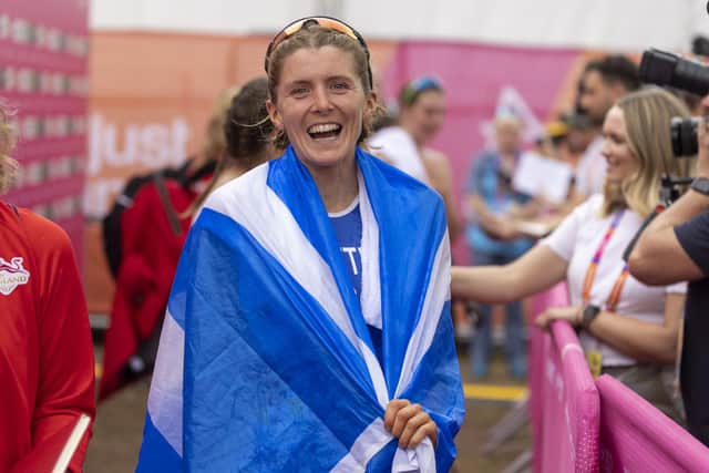 A beaming Beth Potter is draped in the Scotland flag after clinching her bronze medal.