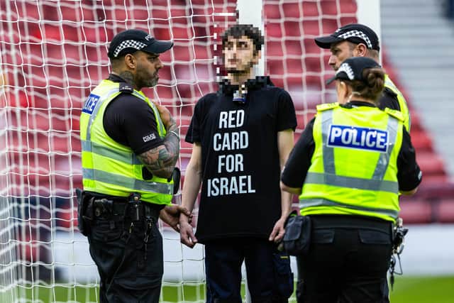 A protestor locked himself to the goal post in protest against Israel during a UEFA European Championship Quallifier between Scotland and Israel at Hampden Park. Photo: Craig Foy / SNS Group