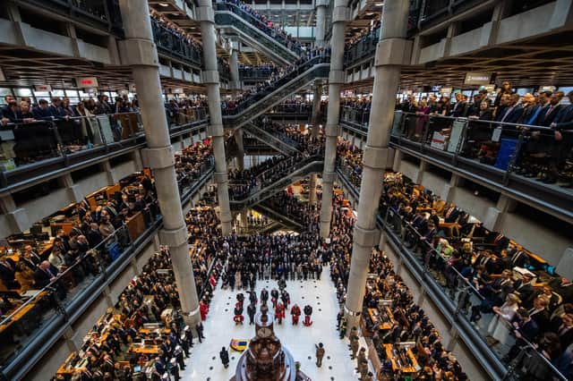 Employees line the balconies and escalators of the famous Lloyd's of London building during a service of Remembrance last year. Picture: Chris J Ratcliffe