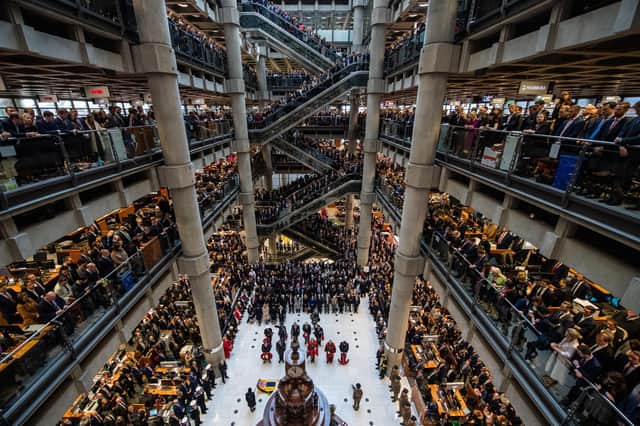 Employees line the balconies and escalators of the famous Lloyd's of London building during a service of Remembrance last year. Picture: Chris J Ratcliffe