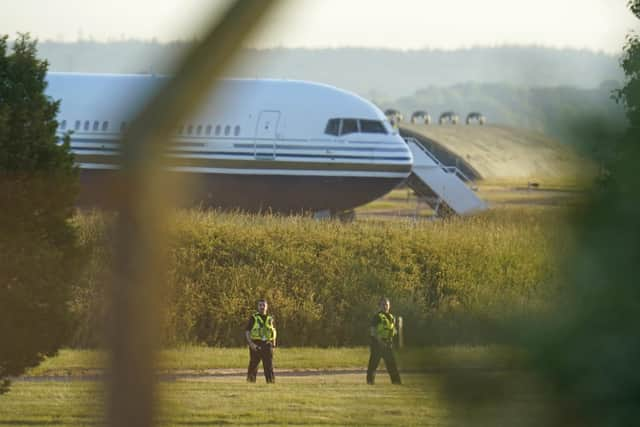 Police officers near a Boeing 767 aircraft at MoD Boscombe Down, near Salisbury, which is believed to be the plane set to take asylum seekers from the UK to Rwanda. Picture: Andrew Matthews/PA