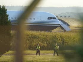 Police officers near a Boeing 767 aircraft at MoD Boscombe Down, near Salisbury, which is believed to be the plane set to take asylum seekers from the UK to Rwanda. Picture: Andrew Matthews/PA