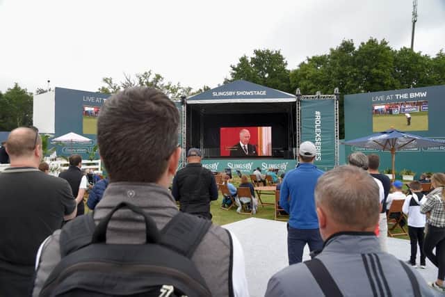 Spectators gather around a huge TV screen in the BMW PGA Championship Spectator Village to watch the proclamation of King Charles III. Picture: Eamonn M. McCormack/Getty Images.