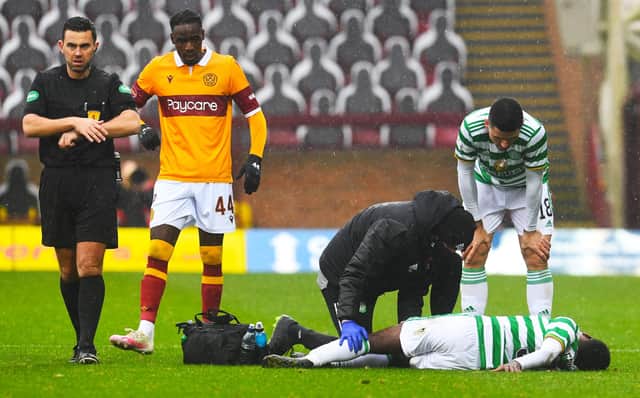Celtic's Jeremie Frimpong is treated for an injury after a tackle from Devante Cole (left) during the away side's 4-1 win over Motherwell. Picture: SNS