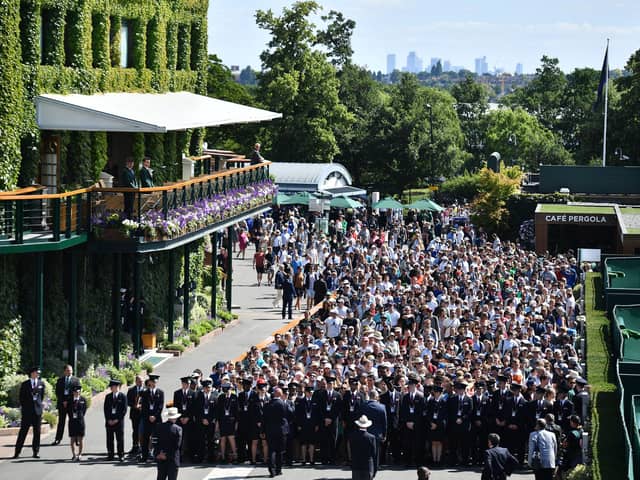 Spectators queue to enter the All England Tennis Club on the first day of the 2019 Wimbledon Championships.