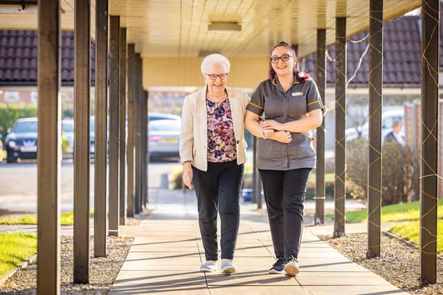 Resident and care home colleague taking a walk outside HC-One care home