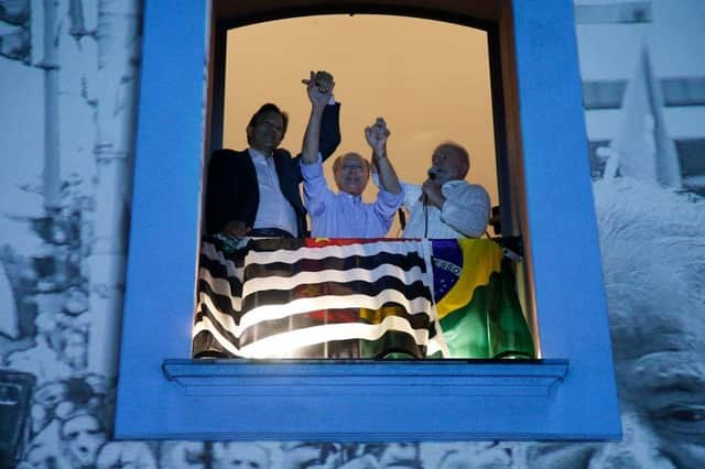 Brazilian former president and presidential candidate for the leftist Workers Party (PT), Luiz Inacio Lula da Silva (R), speaks to supporters holding hands with Sao Paulo Governor candidate Fernando Haddad (L), and Brazil's vice-presidential candidate Geraldo Alckmin.