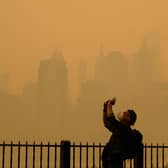 People take photos of the sun as smoke from the wildfires in Canada cause hazy conditions in New York City. Picture: Angela Weiss/AFP via Getty Images