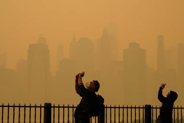 People take photos of the sun as smoke from the wildfires in Canada cause hazy conditions in New York City. Picture: Angela Weiss/AFP via Getty Images