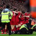 A pitch invader is tackled by stewards after colliding with Andy Robertson of Liverpool as players celebrate after Roberto Firmino's goal against Man Utd.