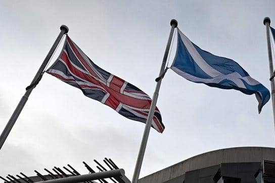 The Union Flag and Saltire of Scotland fly outside the Scottish Parliament