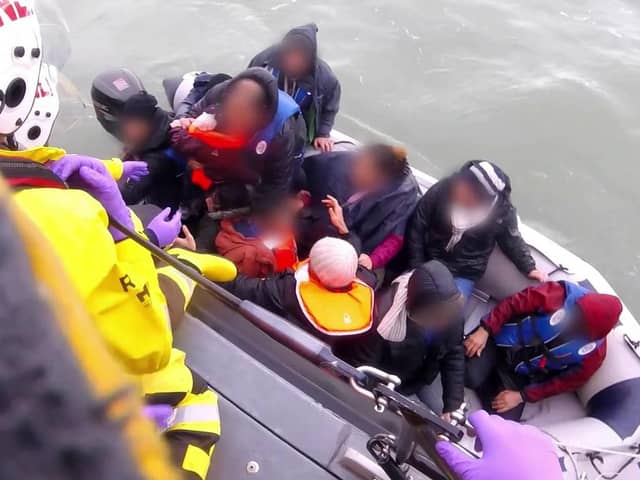 An RNLI boat rescues 12 people, including a baby and child, from a small dinghy in the English Channel in 2019 (Picture: PA)