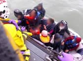 An RNLI boat rescues 12 people, including a baby and child, from a small dinghy in the English Channel in 2019 (Picture: PA)