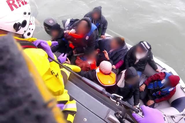 An RNLI boat rescues 12 people, including a baby and child, from a small dinghy in the English Channel in 2019 (Picture: PA)