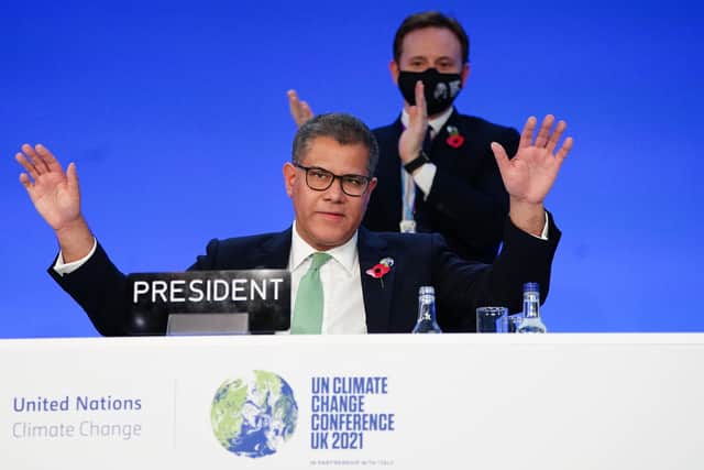 Alok Sharma, President of the COP26 climate summit, raises his hands after his speech of the closing plenary, during an 'overun' day of the summit in Glasgow on Saturday. Photo: Jane Barlow/PA Wire