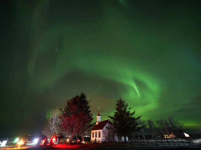 The northern lights are caused when charged particles from solar storms travel towards Earth and react with atmospheric gases