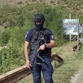 A Kosovo police officer guards the road near the village of Banjska, 35 miles north of the capital Pristina, northern Kosovo. One police officer was killed and another wounded in an attack he blamed on support from neighbouring Serbia, increasing tensions between the two former war foes at a delicate moment in their European Union-facilitated dialogue to normalise ties.