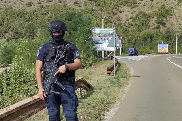 A Kosovo police officer guards the road near the village of Banjska, 35 miles north of the capital Pristina, northern Kosovo. One police officer was killed and another wounded in an attack he blamed on support from neighbouring Serbia, increasing tensions between the two former war foes at a delicate moment in their European Union-facilitated dialogue to normalise ties.