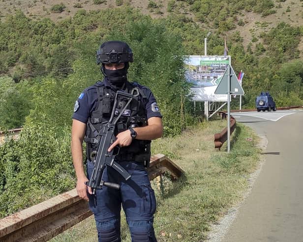 A Kosovo police officer guards the road near the village of Banjska, 35 miles north of the capital Pristina, northern Kosovo. One police officer was killed and another wounded in an attack he blamed on support from neighbouring Serbia, increasing tensions between the two former war foes at a delicate moment in their European Union-facilitated dialogue to normalise ties.