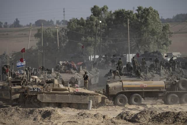 Israeli soldiers organise military equipment while standing on armoured personnel carriers near the border with the Gaza Stip (Picture: Amir Levy/Getty Images)