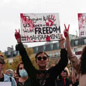 People hold up placards during a rally  in Paris last month in support of the anti-government demonstrations in Iran (Picture: Geoffroy van der Hasselt/AFP via Getty Images)