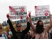 People hold up placards during a rally  in Paris last month in support of the anti-government demonstrations in Iran (Picture: Geoffroy van der Hasselt/AFP via Getty Images)
