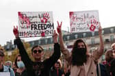 People hold up placards during a rally  in Paris last month in support of the anti-government demonstrations in Iran (Picture: Geoffroy van der Hasselt/AFP via Getty Images)