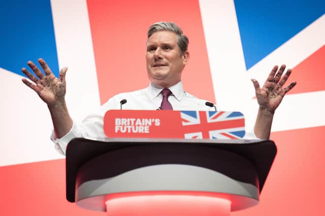 Keir Starmer delivers his keynote speech to the Labour conference in Liverpool with his hands covered in glitter after a protester ran onto the stage (Picture: Stefan Rousseau/PA)