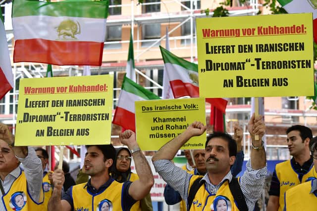 Supporters of the National Council of Resistance of Iran (NCRI) hold placards reading 'Deliver the Iranian diplomat-terrorist to Belgium' during a demonstration calling for the extradition of Assadollah Assadi from Germany to Belgium in July 2018 (Picture: Tobias Schwarz/AFP via Getty Images)