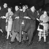 People singing Auld Lang's Syne during New Year at the Tron, Edinburgh 1964