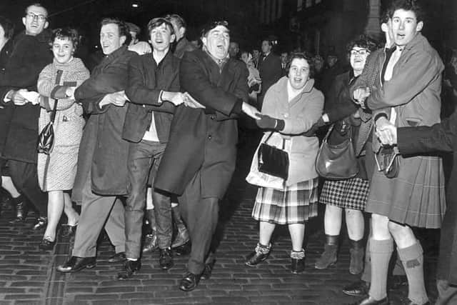 People singing Auld Lang's Syne during New Year at the Tron, Edinburgh 1964