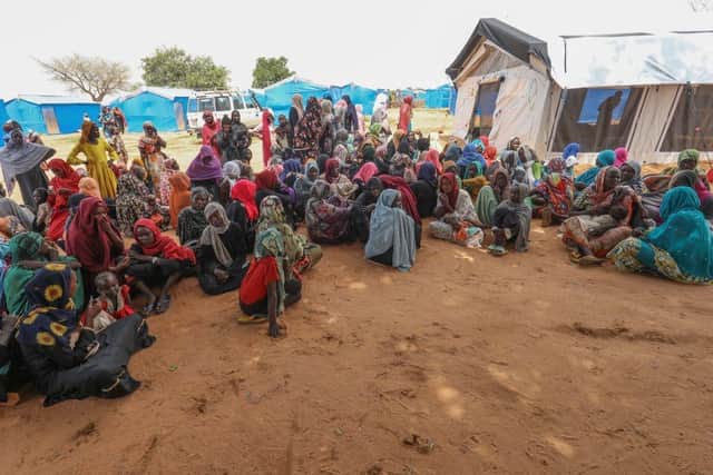 Women who fled the war in Sudan await the distribution of international aid rations at the Ourang refugee camp in eastern Chad last month after hundreds of thousands of refugees fled across Sudan's border.