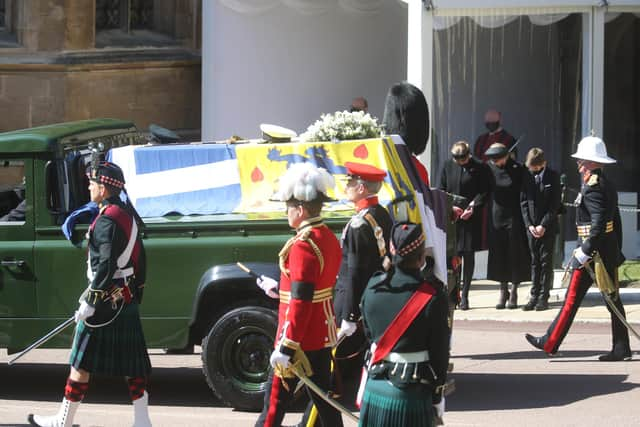 The Duke of Edinburgh's coffin, covered with his Personal Standard, is carried on the purpose built Land Rover Defender