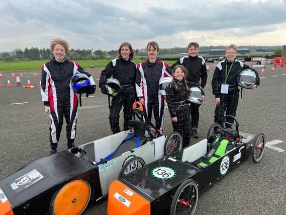 Team GTM young engineers at East Fortune: L-R Rufus Turley, Fergus Dunbar, Harvey Pole, Millie Pole, Edward Cormack, Alexander Brodie with the cars Spyder (L) and Merlin (R)