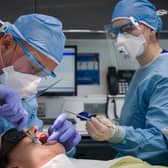 Dentist Fiez Mugha and Dental Nurse Johanna Bartha carry out a procedure on a patient. Photo by Leon Neal/Getty Images