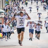 Competitors take part in the Scottish Coal Carrying Championships through the streets of Kelty in Fife.  Picture date: Saturday August 28, 2021. PA Photo. The annual event is one of only two Coal Races in the world and the men's race requires participants to carry a 50-kilo bag of coal and the women's race requires a 25-kilo bag of coal to be carried over 1000 metres through the village. Photo credit should read: Jane Barlow/PA Wire 