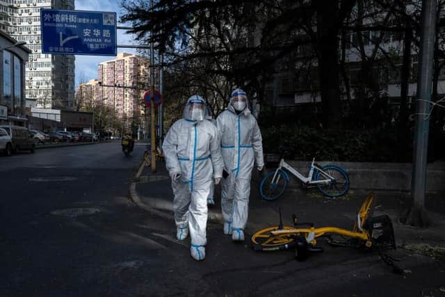 Epidemic control workers wear PPE to prevent the spread of COVID-19 as they walk in an area where communities are in lockdown in China. Protests have broken out around the country, including in Shanghai, where BBC journalist Ed Lawrence was arrested by authorities. Picture: Getty Images