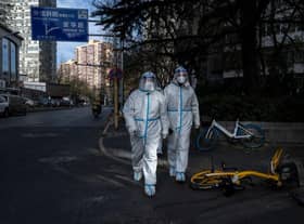 Epidemic control workers wear PPE to prevent the spread of COVID-19 as they walk in an area where communities are in lockdown in China. Protests have broken out around the country, including in Shanghai, where BBC journalist Ed Lawrence was arrested by authorities. Picture: Getty Images