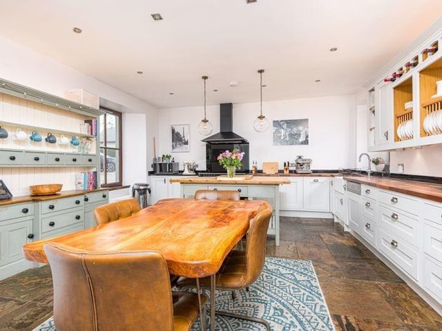 The open plan kitchen/dining area is a substantial space, fitted with wall and base units and solid wood counters, as well as a hood and induction hob and cooker, an integrated dish washer and boiling water tap.